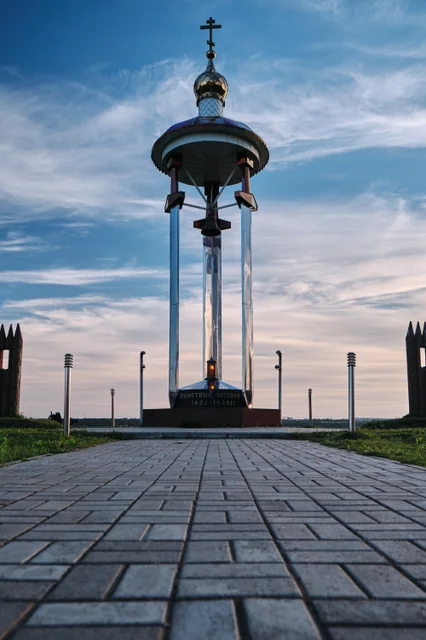 A tall stone monument framed by a blue evening sky.