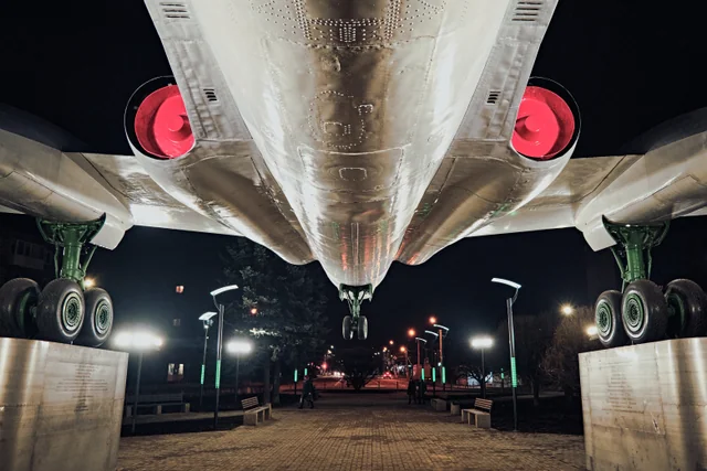 The underside of an aircraft seen head-on, with red engine covers.